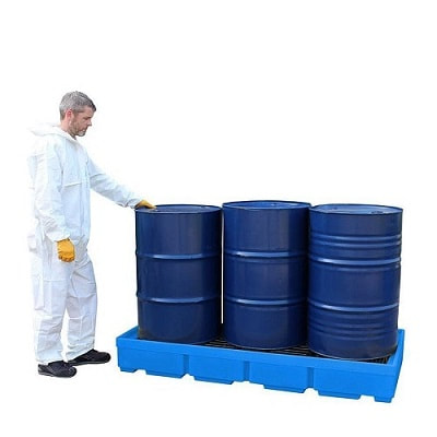 a man standing near spill pallet 3 drums